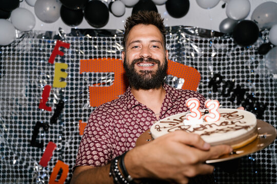 Happy Man Holding Cake with Number Candles