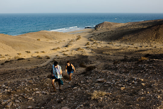 Seascape of Papagayo Beach with a mother and child climbing a hill