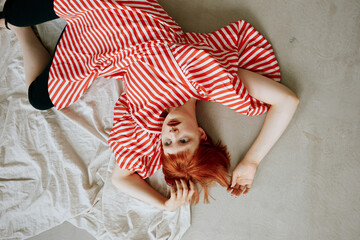 Carefree woman in dress lying on floor