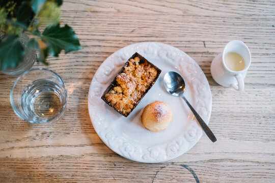 Dessert plate with bun and rectangular treat with spoon