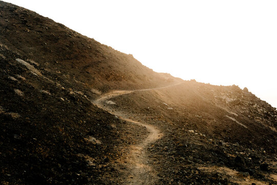 Sunlight illuminating a rocky path on top of a volcanic mountain