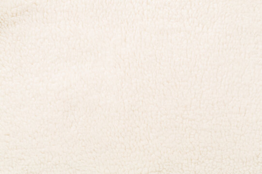 White cuddle teddy bear fabric as background, top view