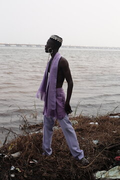  model wearing a hat filled with cowries shells