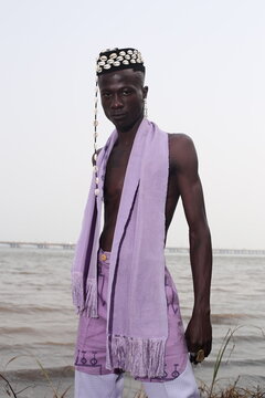  model wearing a hat filled with cowries shells
