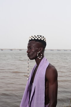  model wearing a hat filled with cowries shells