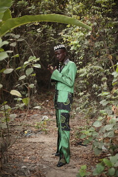 a model in a causal outfit wearing a hat filled with cowries shells
