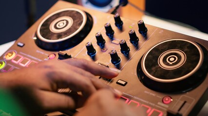 Audio engineer with headset mixing and mastering his recorded files, operating on a professional...