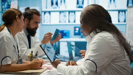 Obraz premium General practitioner collaborates with staff about test results and treatment options, teamwork. Physician with expertise consulting and supporting disease prevention in a facility. Camera B.