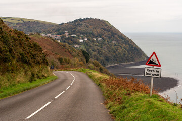 Winding coastal road descending to picturesque village in autumn