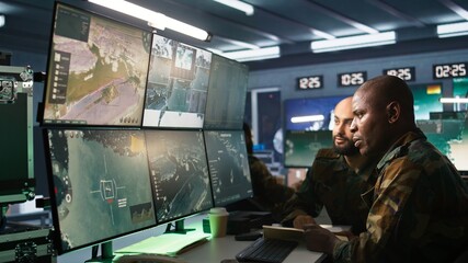 Army officers doing brainstorming in command center, looking at intel folder files. Intelligence...
