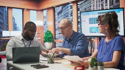 Elderly pair meeting with financial expert to examine various pension options, protect income and investments. Mature couple discuss with advisor about retirement plans and savings. Camera B.