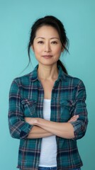 Fototapeta premium Confident Woman in Plaid Shirt Against Blue Background