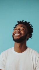 Fototapeta premium Happy Young Man with Natural Hair Against a Teal Background