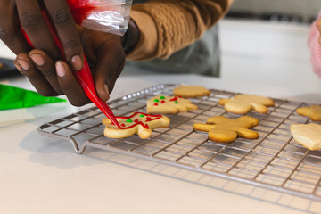 Decorating Christmas cookies with red icing at home, enjoying holiday baking