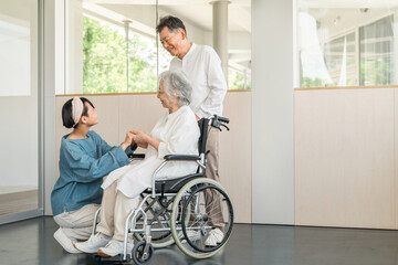 Obraz premium 介護施設を訪れた孫娘と車椅子の祖母と祖父（お見舞い・老人ホーム・介護・入院・病院） 