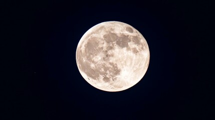 Full moon shining brightly in dark sky, casting gentle light over night landscape, creating serene scene.