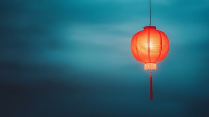 Obraz premium Red lantern hanging from string against clear sky, casting soft glow, evoking warmth and tranquility.