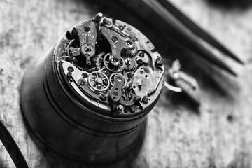 Detailed watch mechanism placed on workbench in monochrome