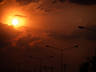 Yellow Sunset in The Red Sky near The Lights from Silhouette Electric Poles
