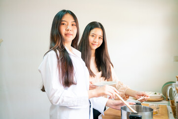 Fototapeta premium Happy asian women cooking breakfast food in home kitchen together