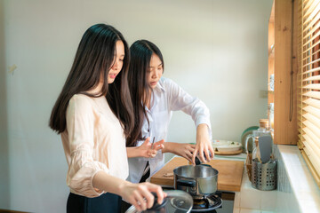 Fototapeta premium Happy asian women cooking breakfast food in home kitchen together