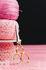 Close-up of balls of yarn and ribbon next to beautiful iron scissors, perfect for knitting,...