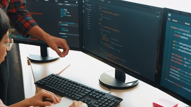 Slow motion back end or software developer manager supervising his team on new application program development on debugging and solving complex code algorithms on monitor. Burgeoning