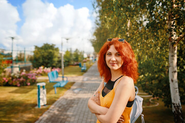 A cheerful woman strolls through a sunlit park, surrounded by vibrant greenery, blooming flowers, and natures beauty