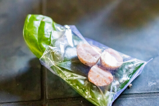 Close-up of Indian paan or betel leaves and supari or areca nuts neatly packed in a plastic pouch, ready for use as a traditional mouth freshener or cultural offering.