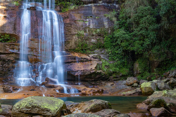 Wei sohphoh waterfall flowing down from rocky hills of meghalaya. Long exposure photo of white streams with vibrant green lagoon water