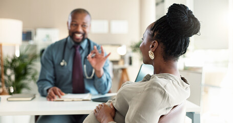 Obraz premium Healthcare, okay or pregnancy with doctor and patient in office at hospital for consulting or positive feedback. Gesture, smile and medical professional man talking to pregnant woman in clinic