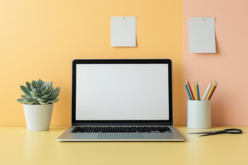 Fototapeta premium Minimalist desk setup on a light yellow surface. Centered silver laptop with blank white screen. white ceramic pencil holder with scissors and colored pencils. and a small white pot with a succulent