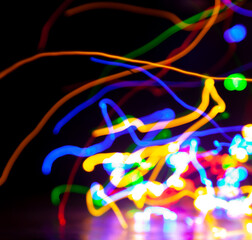 Multi-colored traces of long exposure electric lights on black background....