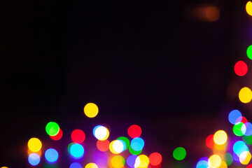 Bright round colored highlights are randomly located below black background....