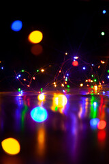 Lights of New Year electric garland reflect from smooth surface....