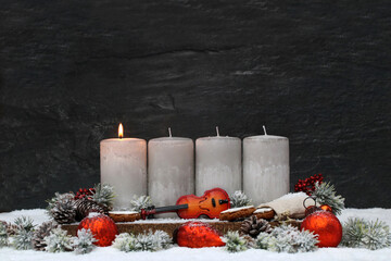 First Advent: Advent decoration with grey candles, violin and Christmas decorations in the snow on...