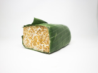 Indonesian Tempe or fermented soybeans. Typical soybean food wrapped in banana leaves. The tempe is...