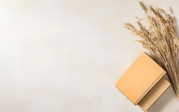 Aesthetic flat lay of a closed notebook and dried grass on a neutral background in natural light