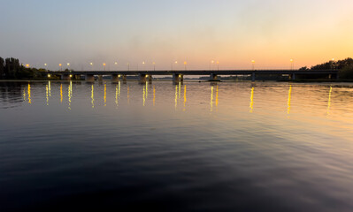 Obraz premium A bridge spans a river at sunset