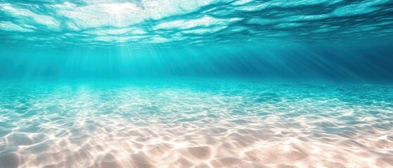 Underwater scene showcasing sunlight filtering through the ocean surface onto sandy seabed.