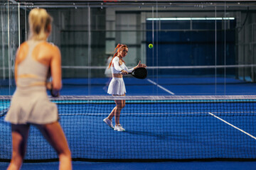 Fototapeta premium Female padel player showing her skill at the net