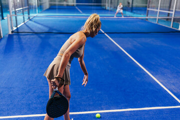 Female padel player preparing to serve