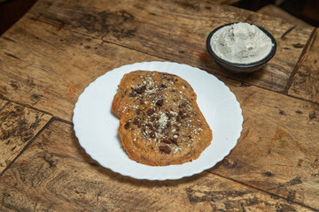 Chocolate chip cookie, Chocolate cookie with chocolate dips and ice cream flavor of vanilla, Chocolate cookie placed in a wooden dining table