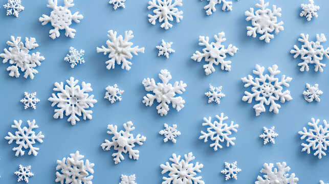 White snowflakes on a plain white or blue background, highlighting their unique symmetrical patterns