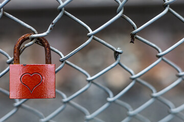 A photo showing a padlock with hearts, symbolizing a strong relationship between two people. A great symbol for Valentine's Day or a wedding. The broken wire illustrates the problems we have to overco