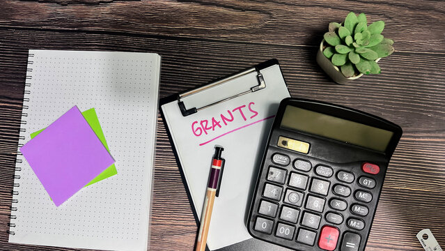 Concept of Grants write on paperwork isolated on wooden background.