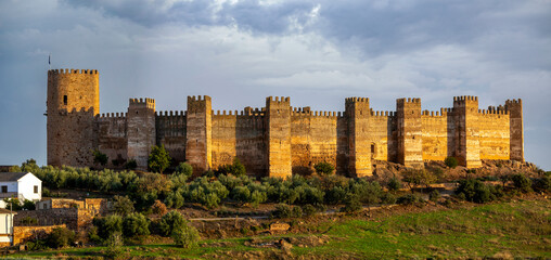 Spectacular full view of the walls and turrets of the medieval castle of Burgalimar in Baños de la Encina, Jaén, Andalusia, Spain with evening light © AntonioLopez