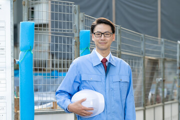 建設現場に立つ作業服の男性