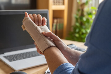 Person Using Wrist Brace For Hand Injury Due To Remote Computer Work, Showing Carpal Tunnel...