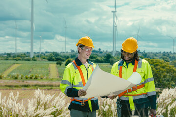 Engineer team mix black and white male workers with floor plan at Wind Turbines field working...